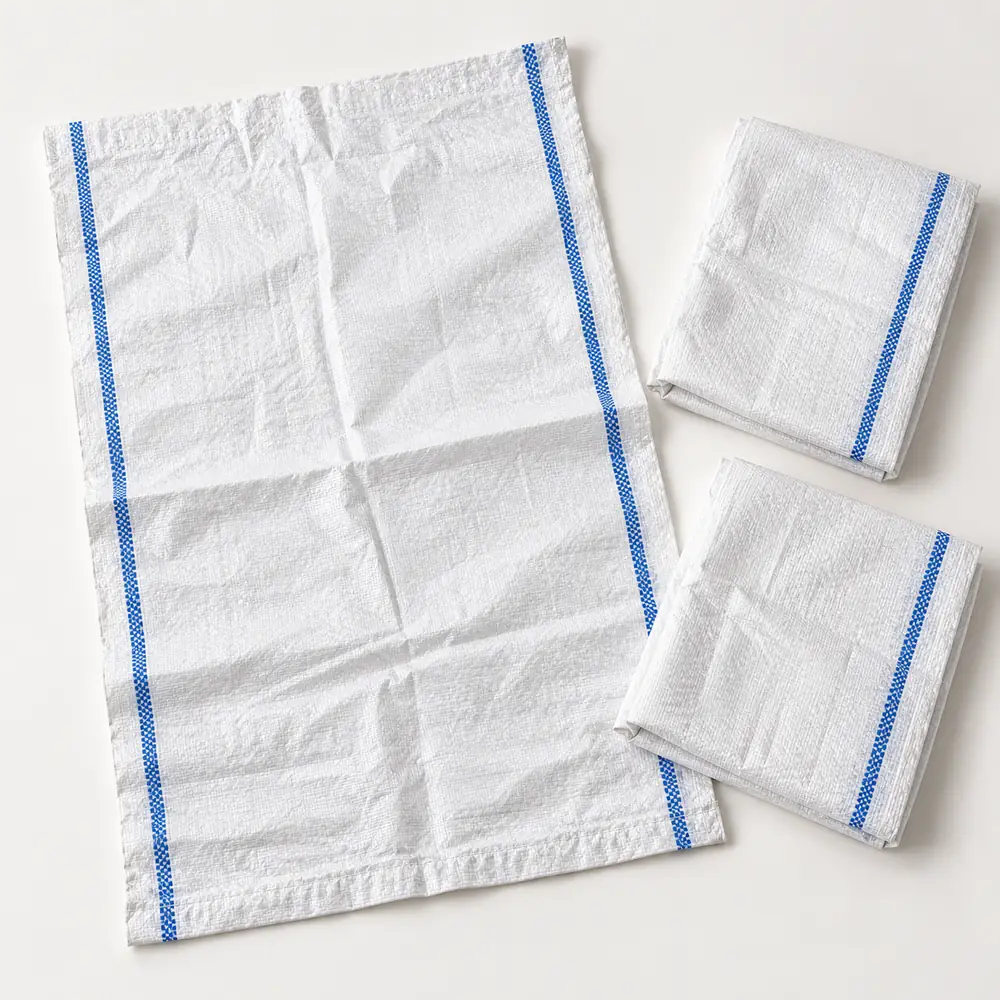 White woven polypropylene rubble sacks with blue stripes, one laid flat and two folded